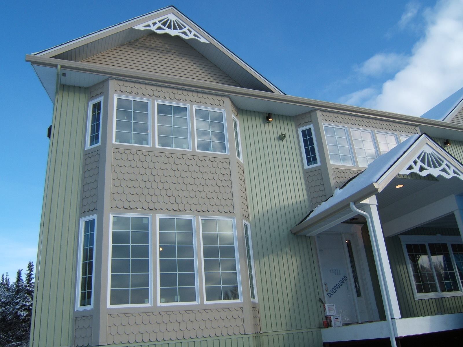 Victorian style house with shingled bay turret and green siding
