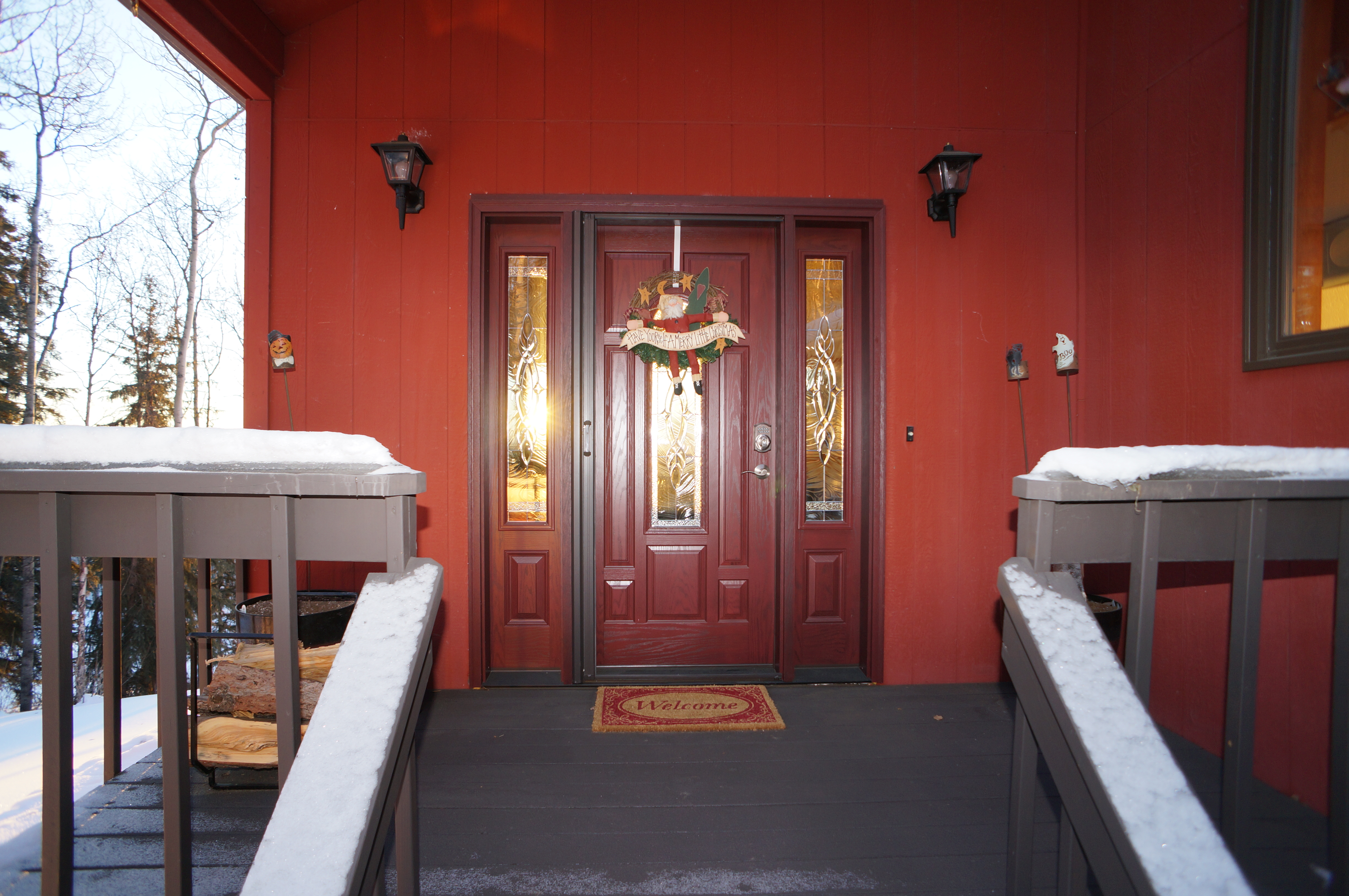 Snowy front porch with dark red door
