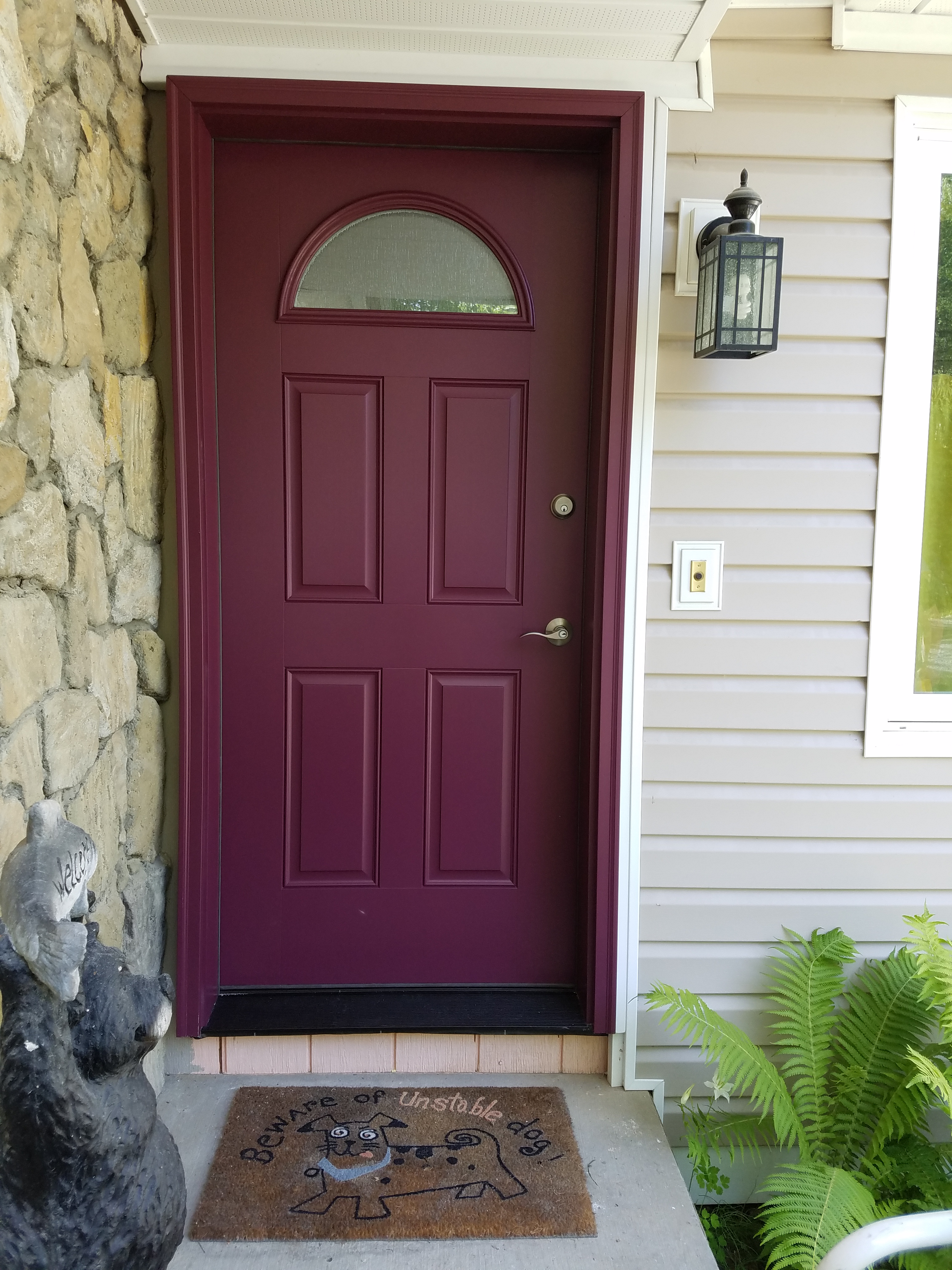 Front porch of home featuring new installed maroon door