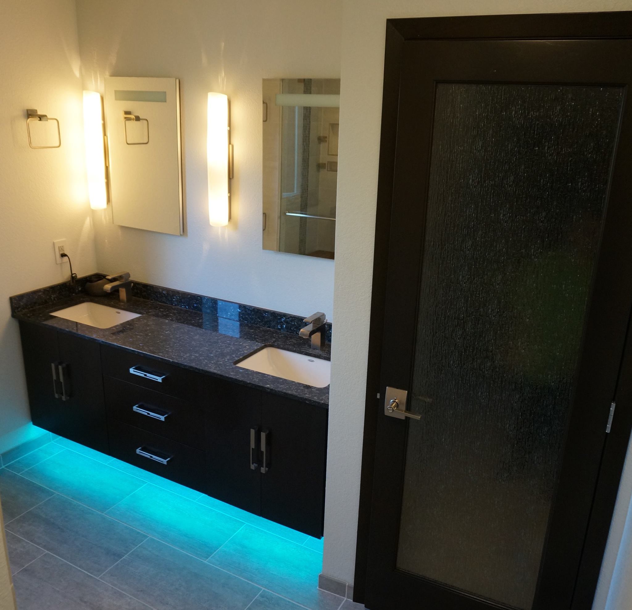 Bathroom with interesting blue recessed lighting underneath cabinets