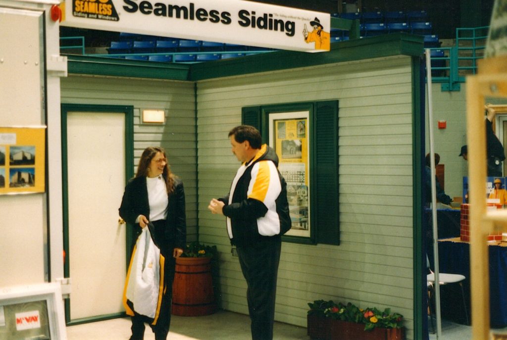 Owner discussing ABC siding with co-worker at Fairbanks home show