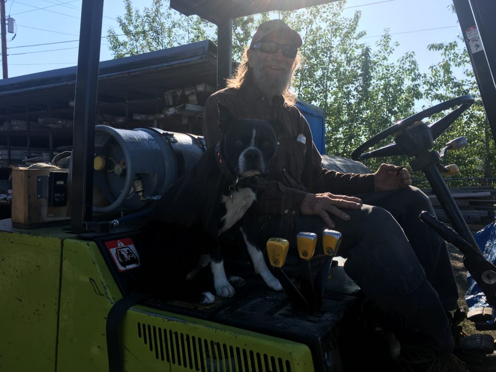 Employee of ABC Inc riding a fork lift with boston terrier